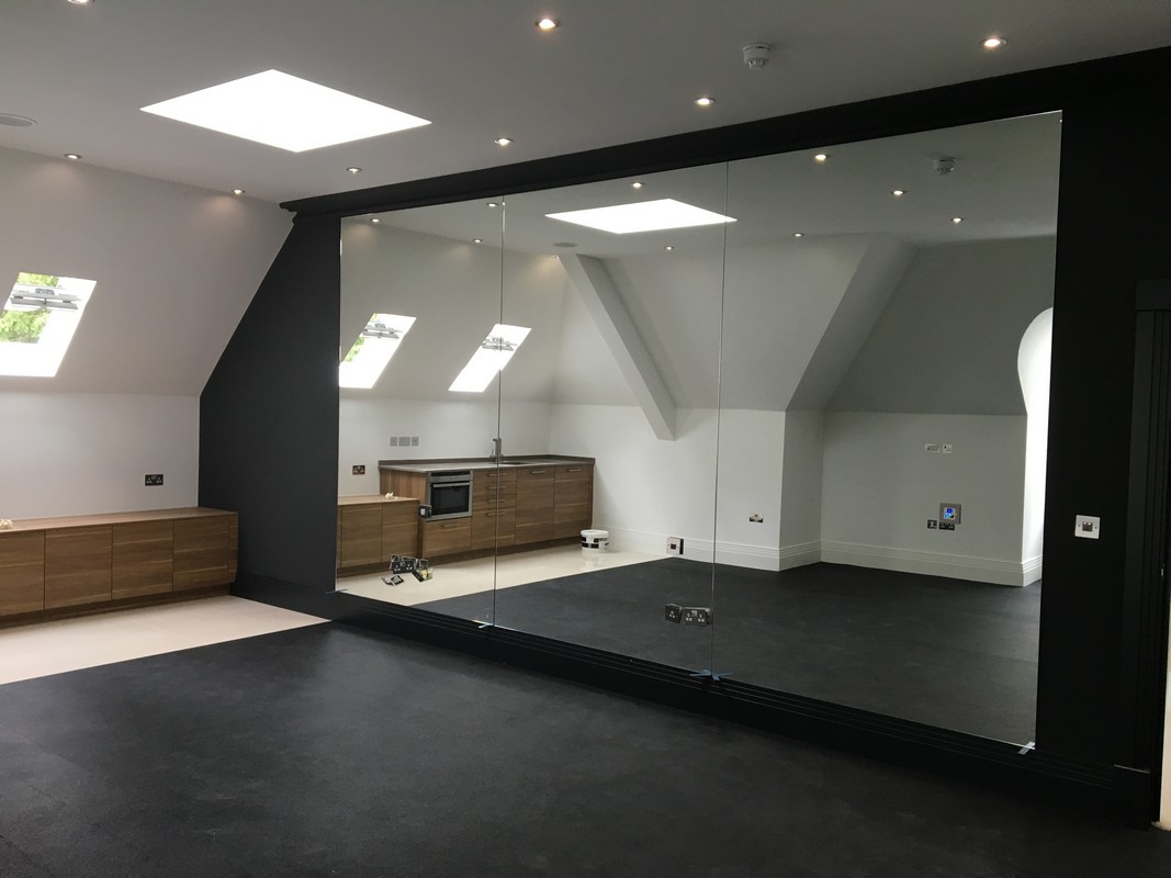 Frameless glass wall dividing loft conversion in Swiss Cottage
